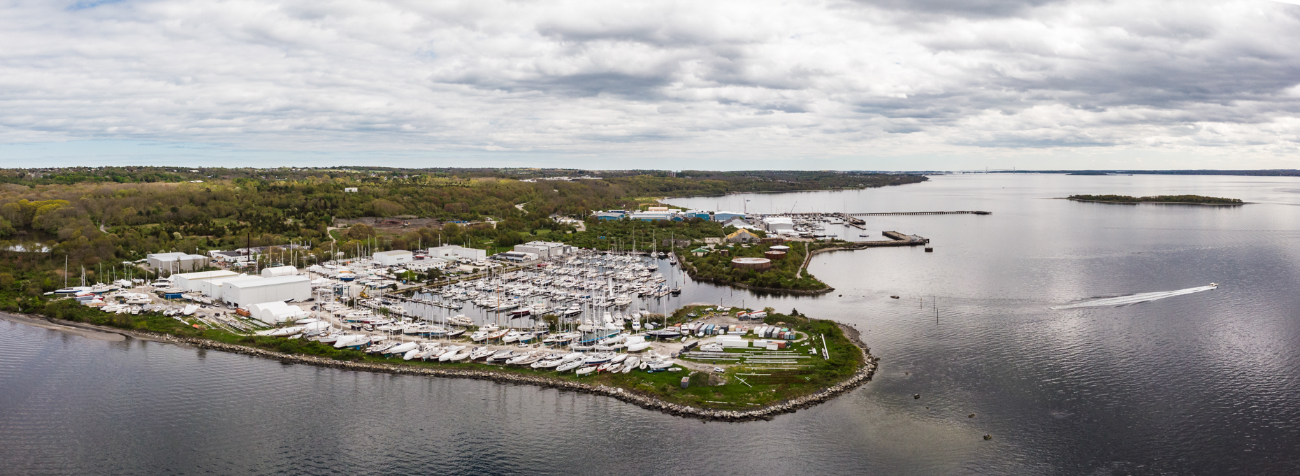 Aerial photo of Safe Harbor Marina with a boat exiting in Portsmouth RI, image taken by Architectural Photographers in North Carolina
